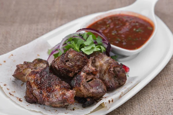 Beyaz bir plaka üzerinde ızgara kuzu şiş