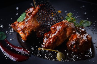 Siyah bir zemin üzerine soslu et kaburga