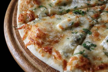 Tahtada dört peynirli pizza.