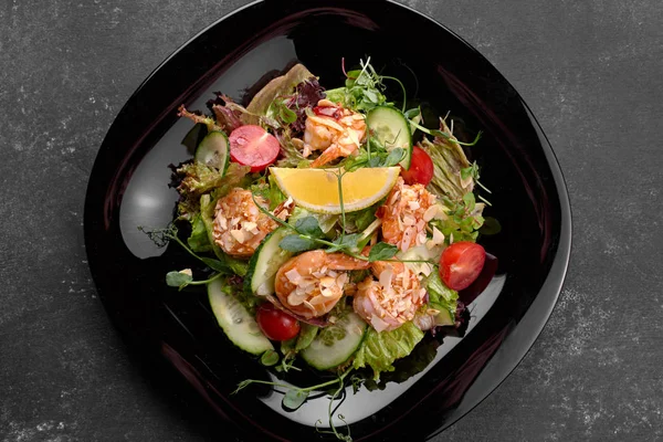 Овощной салат с креветками, на черном фоне — стоковое фото