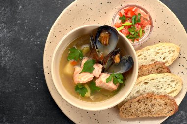 Deniz ürünleri çorbası, midye balığı, balık çorbası, siyah arka planda.