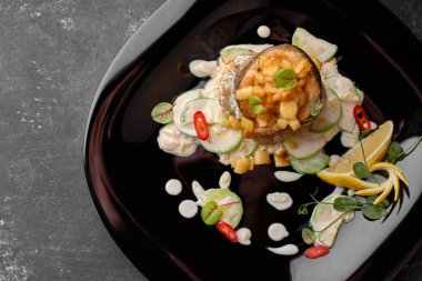 Siyah arka planda sebzeli ızgara alabalık filetosu.