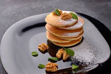 Siyah tabakta bal ve fındıklı börek.