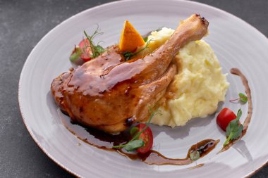 Soslu ördek budu, patates püresi ve siyah bir sırt.