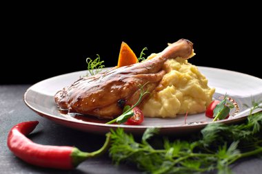 Soslu ördek budu, patates püresi ve siyah bir sırt.