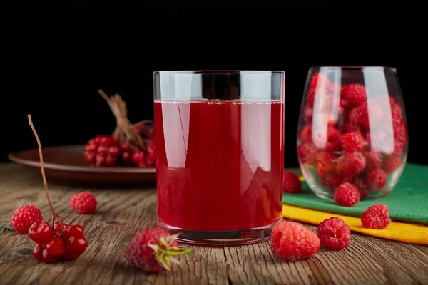 A glass of natural raspberry and cranberry juice on a wooden boa — Stock Photo, Image