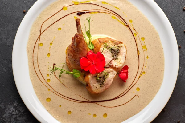Stuffed duck leg with sauce, on a white plate, on a dark backgro — 스톡 사진