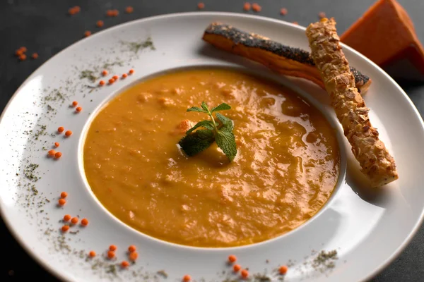 Pumpkin cream soup, on a black background — Stockfoto