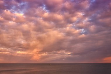 Güzel bir gün doğumu, denizde gün batımı. Kırmızı, gri, pembe, sarı bulutlar