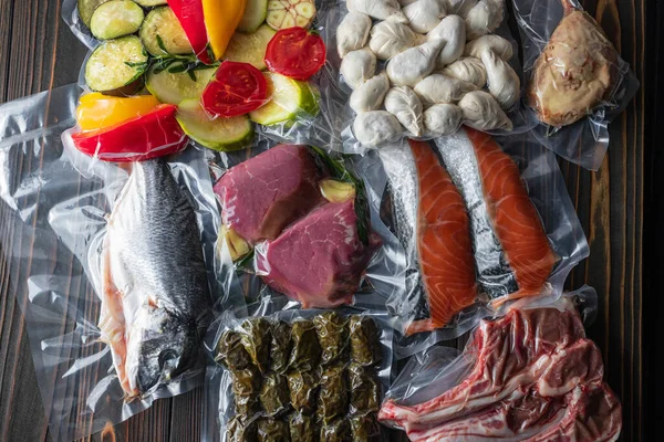 Tahta bir tahtanın üzerinde vakumlu ambalaj ürünleri. Sebze, balık eti, dolma, kurza. Karantina Salgını