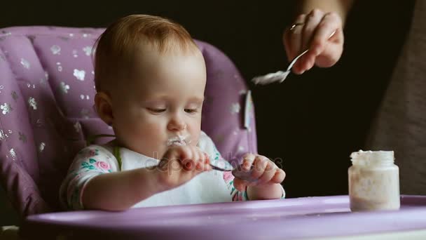 Faim bébé garçon être nourri un repas dans un cadre à la maison . — Video