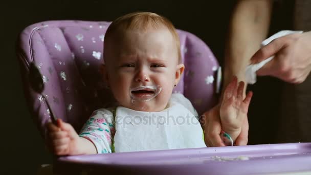Närbild av en pojke gråter medan han är hand matas. — Stockvideo