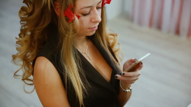 Concepto de belleza, peinado y gente - mujer joven feliz con teléfono inteligente y peluquería haciendo peinado en el salón — Vídeos de Stock