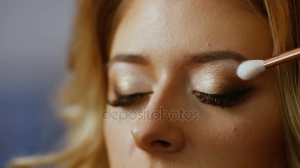 Make-up artist tillämpa färg ögonskuggor på modeller ögon, närbild. — Stockvideo