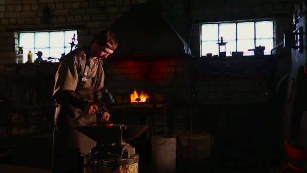 El herrero forja manualmente el metal fundido en el yunque en la herrería con fuegos artificiales de chispa — Vídeos de Stock