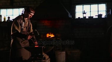 El ile smithy kıvılcım havai fişek ile örs üzerinde sıcak metal dövme demirci.