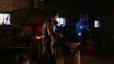 El ile smithy kıvılcım havai fişek ile örs üzerinde sıcak metal dövme demirci.