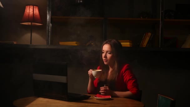 Chica trabajando con portátil bebiendo café Fumar un cigarrillo electrónico. Trabajando remotamente en un café . — Vídeo de stock