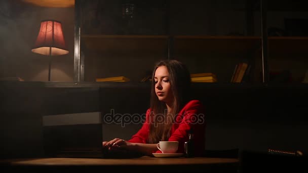 Chica trabajando con portátil bebiendo café Fumar un cigarrillo electrónico. Trabajando remotamente en un café . — Vídeos de Stock