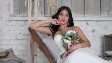 Gelin güzel bir esmer, güzel bir iç bir boho tarzında bir kanepede yatıyor