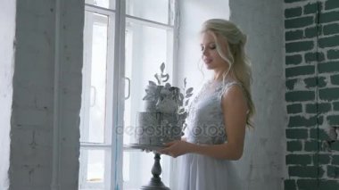 Gelin düğün elbisesini vasıl belgili tanımlık pencere ile güzel bir düğün pastası standları.