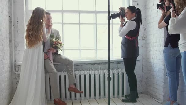 Жених и невеста позируют фотографу на мастер-классе. Модели сфотографированы. Бекстейджмент фотосессия влюбленных. Фотография обучена . — стоковое видео