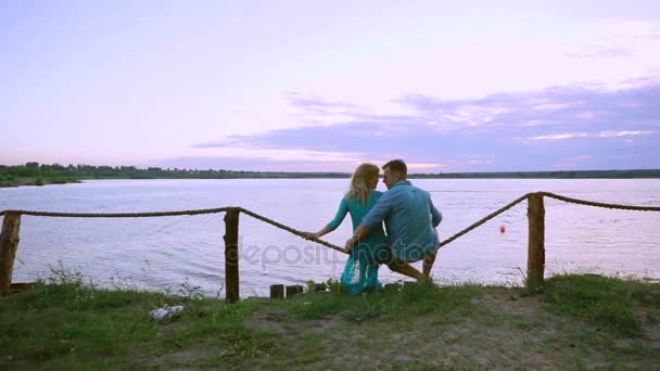 Älskande par på stranden kyssa och krama titta på solnedgången och tävlingar på vatten motorcyklar. Hydro-cykel. — Stockvideo