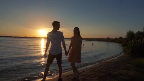Silhueta de um casal apaixonado em um pôr do sol fundo tropical . — Vídeo de Stock