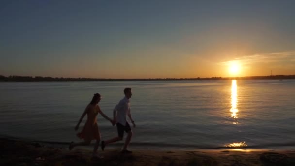 Lyckliga par som springer på stranden — Stockvideo