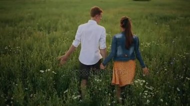 Muhteşem mutlu çift gün batımında eğleniyor. Ekose gömlek giyen yakışıklı beyaz adam ekose gömlekli, gülümseyen bir kıza nazikçe sarılıyor. Yaşam tarzı ve seyahat konsepti.