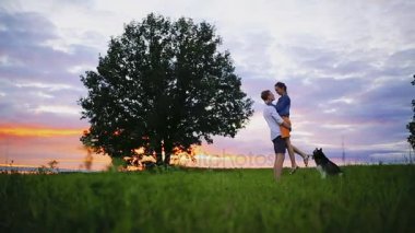 Plajda köpekle oynamayı seven çift. Aşk, hayvan ve yaşam tarzı hakkında kavramı