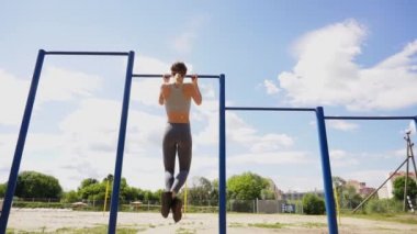 Çekme işi açık spor salonunda çalışan genç atletik fitness kadın ups güneş doğarken