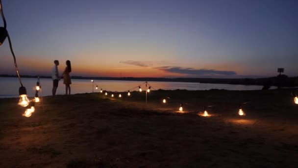 Par promenader längs piren vid solnedgång över havet — Stockvideo