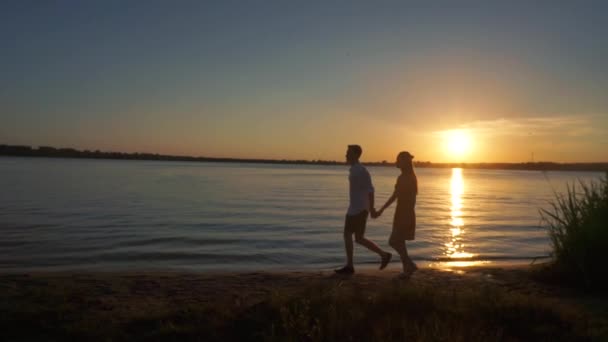 Silueta de una pareja enamorada sobre un fondo tropical al atardecer . — Vídeos de Stock