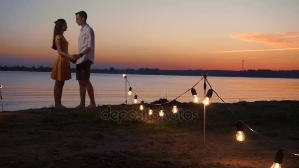 Couple marche le long de la jetée au coucher du soleil sur la mer — Video