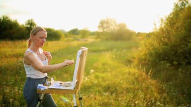 Genç ressam sonbahar manzarası çiziyor.