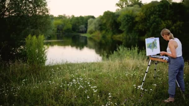 La muchacha con el entusiasmo dibuja las pinturas sobre el papel el paisaje — Vídeos de Stock
