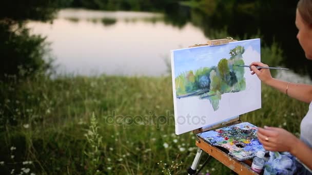 A menina com o entusiasmo desenha pinturas em um papel uma paisagem — Vídeo de Stock