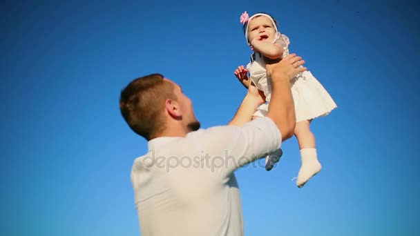小さな娘と遊ぶの父親が自分たちの手でスローします。. — ストック動画
