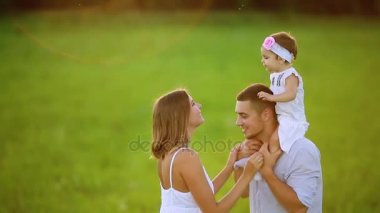 Mutlu aile: anne baba ve kız gün batımında doğada