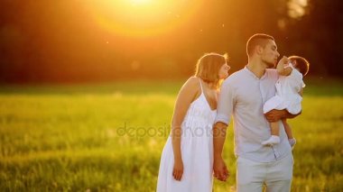 Mutlu genç aile yaz sahada yürüyüş çocuk ile. Sağlıklı anne, baba ve küçük kızı kız doğanın keyfini birlikte, açık havada. Günbatımı.