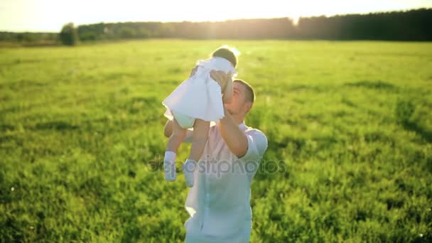 Father playing with little daughter throws on their hands. — Stock Video