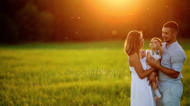 Familia feliz: madre padre e hija en la naturaleza al atardecer — Vídeos de Stock