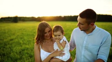 Parkta gün batımında mutlu yedi yürür. Beyaz giysiler, güneş, yaz.