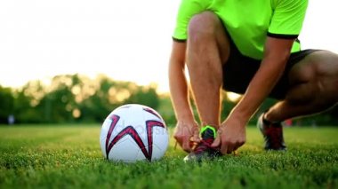 Dantel çizmeler içinde bağlama uygulama profesyonel futbol oyuncu. Topu ile yakın çekim.
