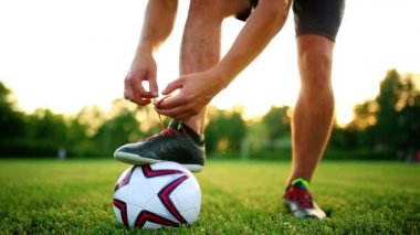 Dantel çizmeler içinde bağlama uygulama profesyonel futbol oyuncu. Topu ile yakın çekim.