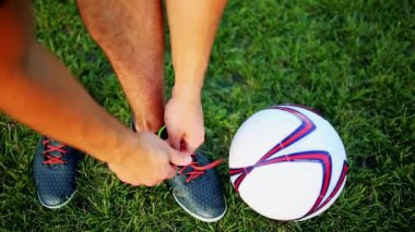 Dantel çizmeler içinde bağlama uygulama profesyonel futbol oyuncu. Topu ile yakın çekim.