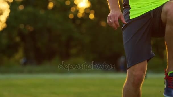 Επαγγελματίας ποδοσφαιριστής και ένας άνθρωπος σε μια πράσινη στολή, γόνατα ταχυδακτυλουργίες την μπάλα ποδοσφαίρου. — Αρχείο Βίντεο