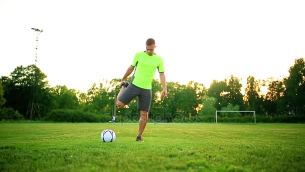 Футболист греется на стадионе в солнечный день — стоковое видео