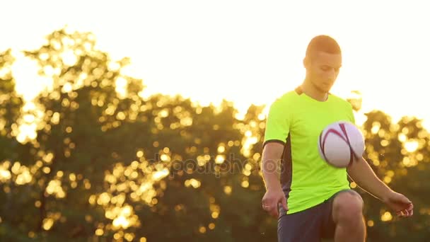 Un giocatore di calcio professionista e un uomo in uniforme verde, ginocchia giocoliere il pallone da calcio . — Video Stock